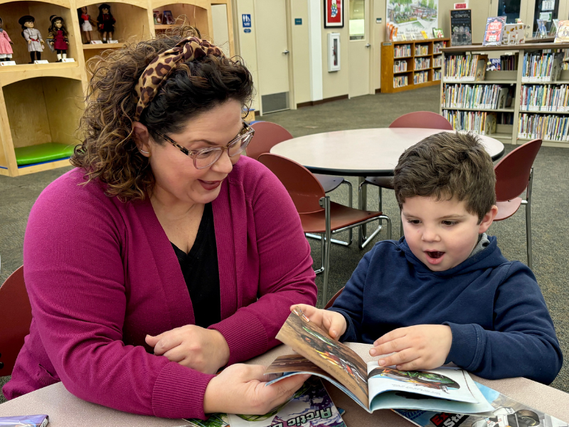 Mother and son reading books in the library